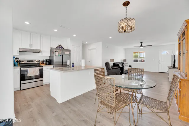 a kitchen with stainless steel appliances kitchen island granite countertop a table and chairs in it
