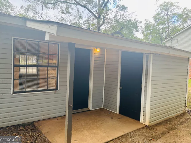 a view of a porch with a door and wooden floor