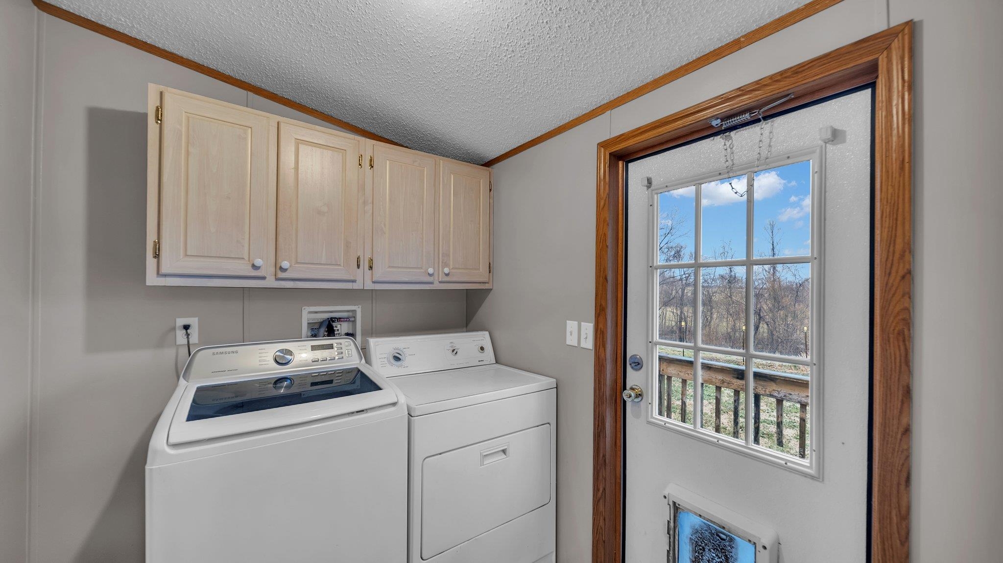 296 Adkins Road Burlison, TN 38015 - Photo 15 of 28 Laundry area featuring cabinet space and back door. Washer and Dryer Stays