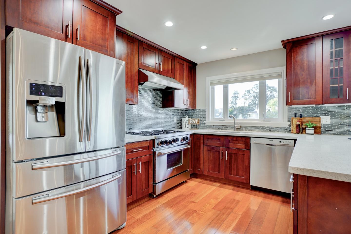 1112 Millbrae Avenue Millbrae, CA 94030 - Photo 26 of 100 a kitchen with stainless steel appliances granite countertop a refrigerator a sink dishwasher a stove with wooden floor and cabinets