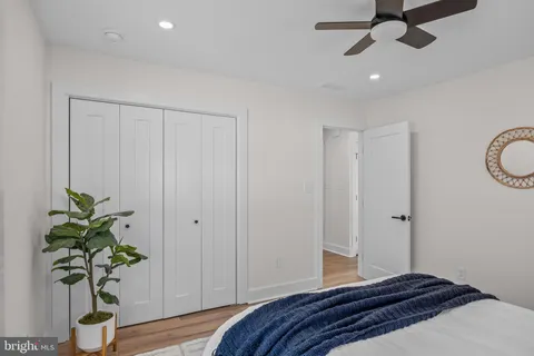 a bedroom with a potted plant on the counter and a wooden floor