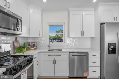 a kitchen with stainless steel appliances granite countertop a sink stove and cabinets