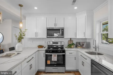 a kitchen with white cabinets and white appliances