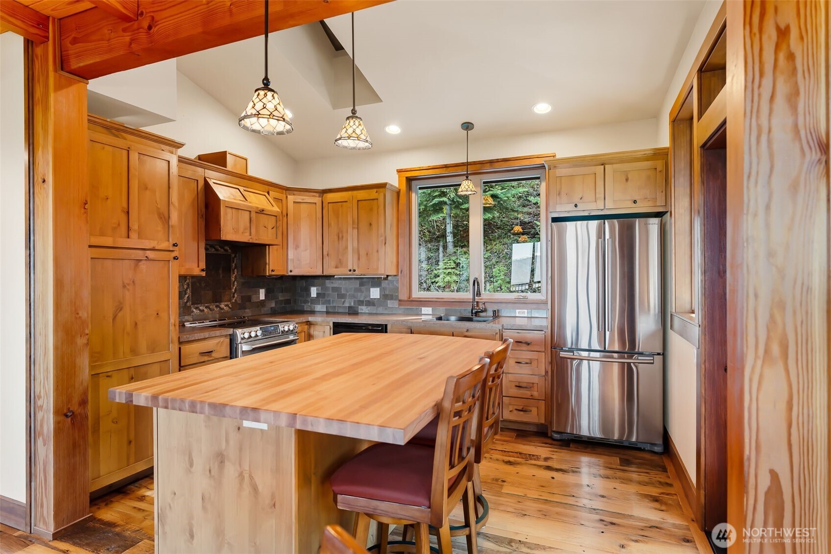 824 Huntrick Drive Cle Elum, WA 98922 - Photo 14 of 38 a kitchen with stainless steel appliances granite countertop a refrigerator a sink dishwasher a stove a dining table and chairs with wooden floor