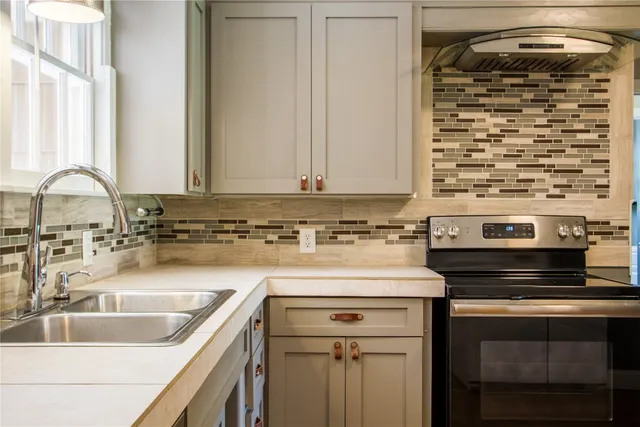 a kitchen with a sink stove and cabinets