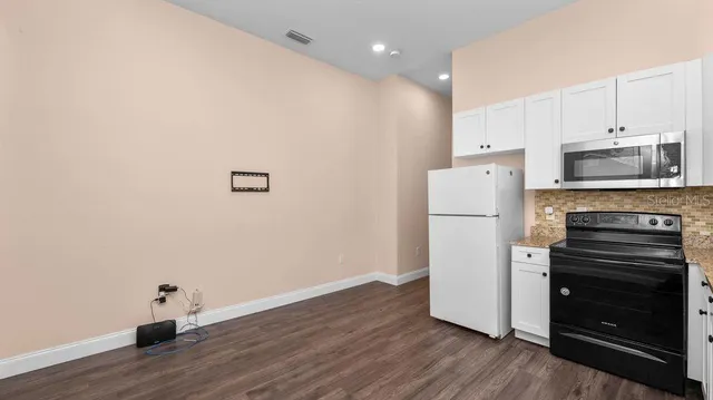 a kitchen with a refrigerator and a stove top oven