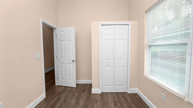 a view of a hallway with wooden floor and a window