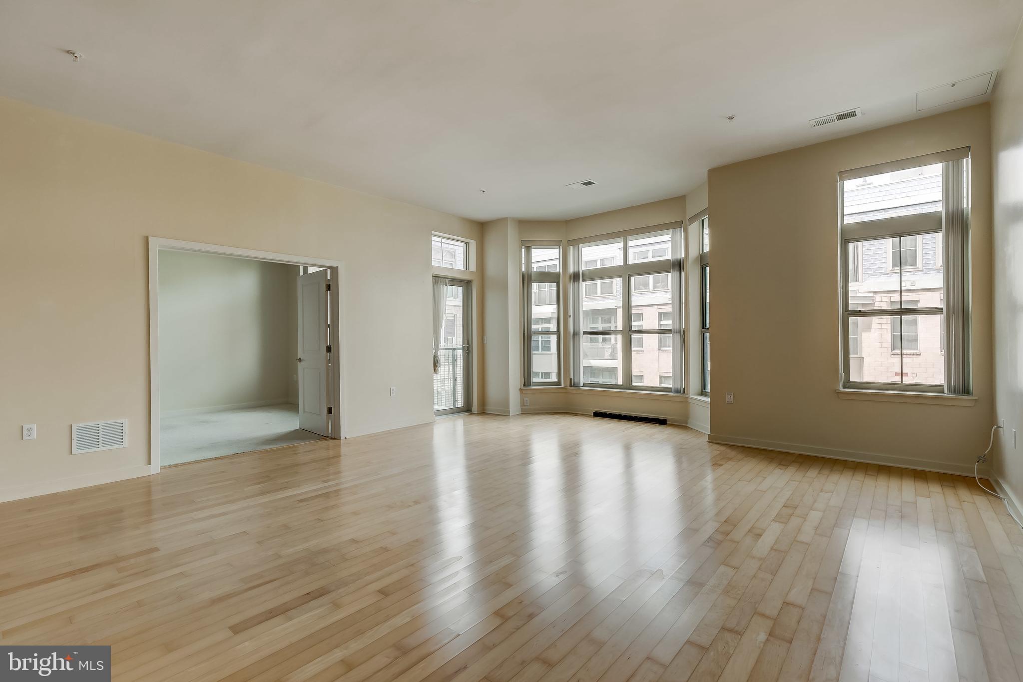 1209 North Charles Street, Unit 304 Baltimore, MD 21201 - Photo 14 of 37 an empty room with wooden floor and windows