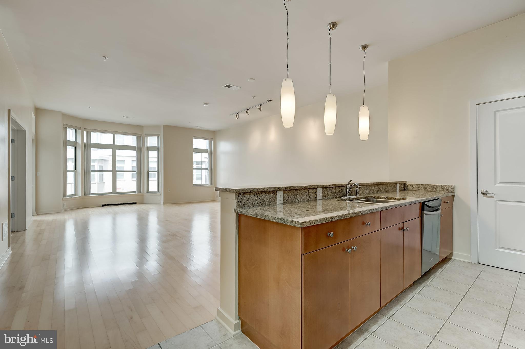 1209 North Charles Street, Unit 304 Baltimore, MD 21201 - Photo 2 of 37 a kitchen with stainless steel appliances granite countertop a stove and a wooden floor
