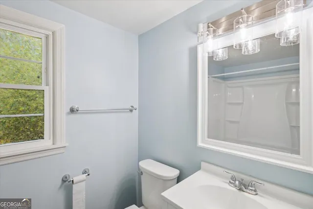 a bathroom with a toilet a sink and mirror