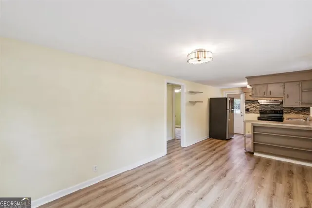 a view of empty room with wooden floor