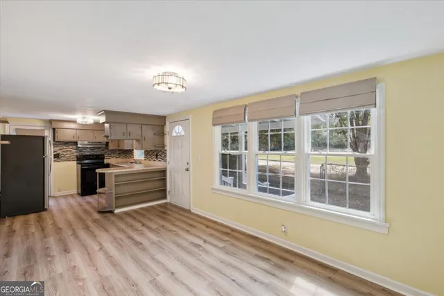 a kitchen with granite countertop a refrigerator and wooden floor