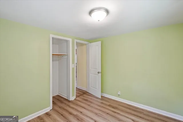 an empty room with wooden floor and closet