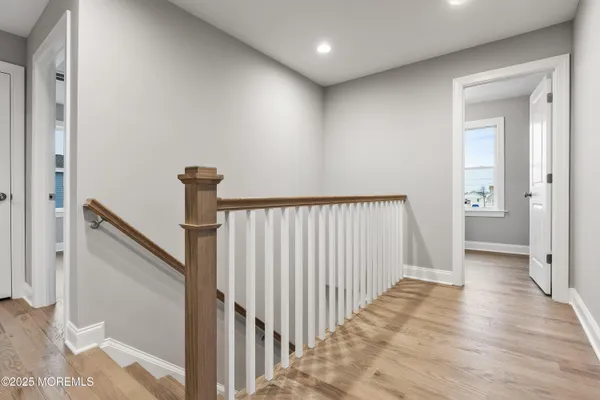 a view of a hallway with wooden floor and staircase