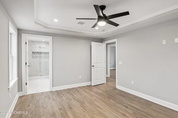 a view of empty room with wooden floor and ceiling fan