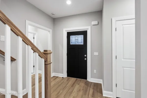 a view of a hallway with wooden floor and entryway