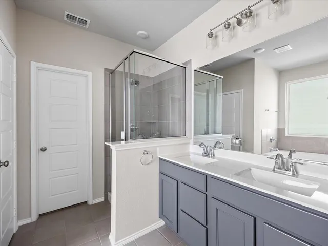 a bathroom with double sink and a mirror