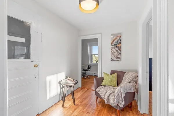 a living room with furniture and a painting on the wall
