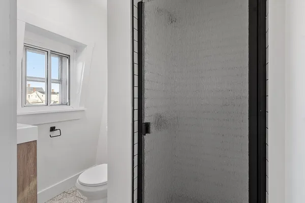 a white toilet sitting next to a bathroom sink and vanity