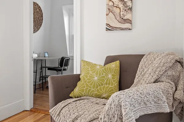 a view of a bedroom with furniture and wooden floor