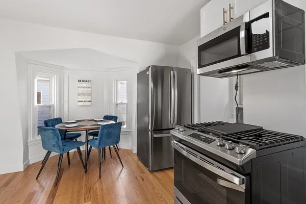 a kitchen with stainless steel appliances granite countertop a stove a refrigerator and a dining table