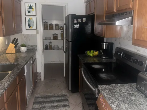 a kitchen with granite countertop a refrigerator and a stove