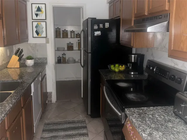 a kitchen with granite countertop a refrigerator and a stove