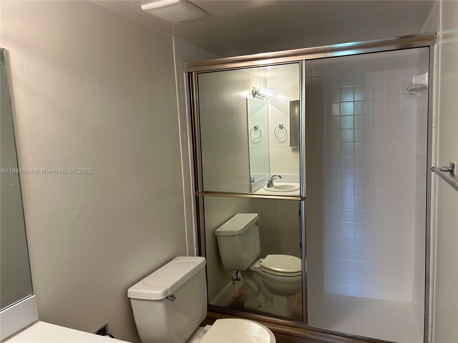 9430 Live Oak Place, Unit 404 Davie, FL 33324 - Photo 11 of 28 a white toilet sitting next to a shower and a bathroom sink