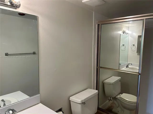 a white toilet sitting next to a bathroom sink