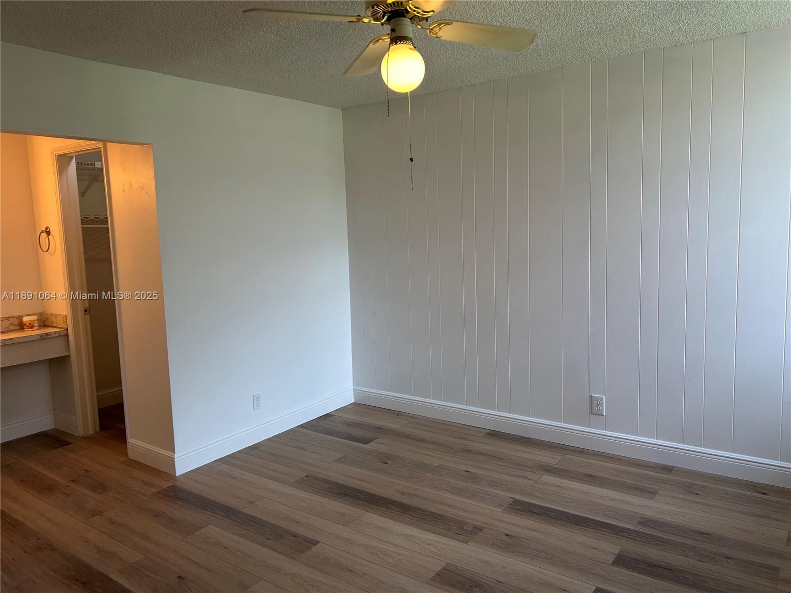 9430 Live Oak Place, Unit 404 Davie, FL 33324 - Photo 13 of 28 a view of a room with wooden floor and fan