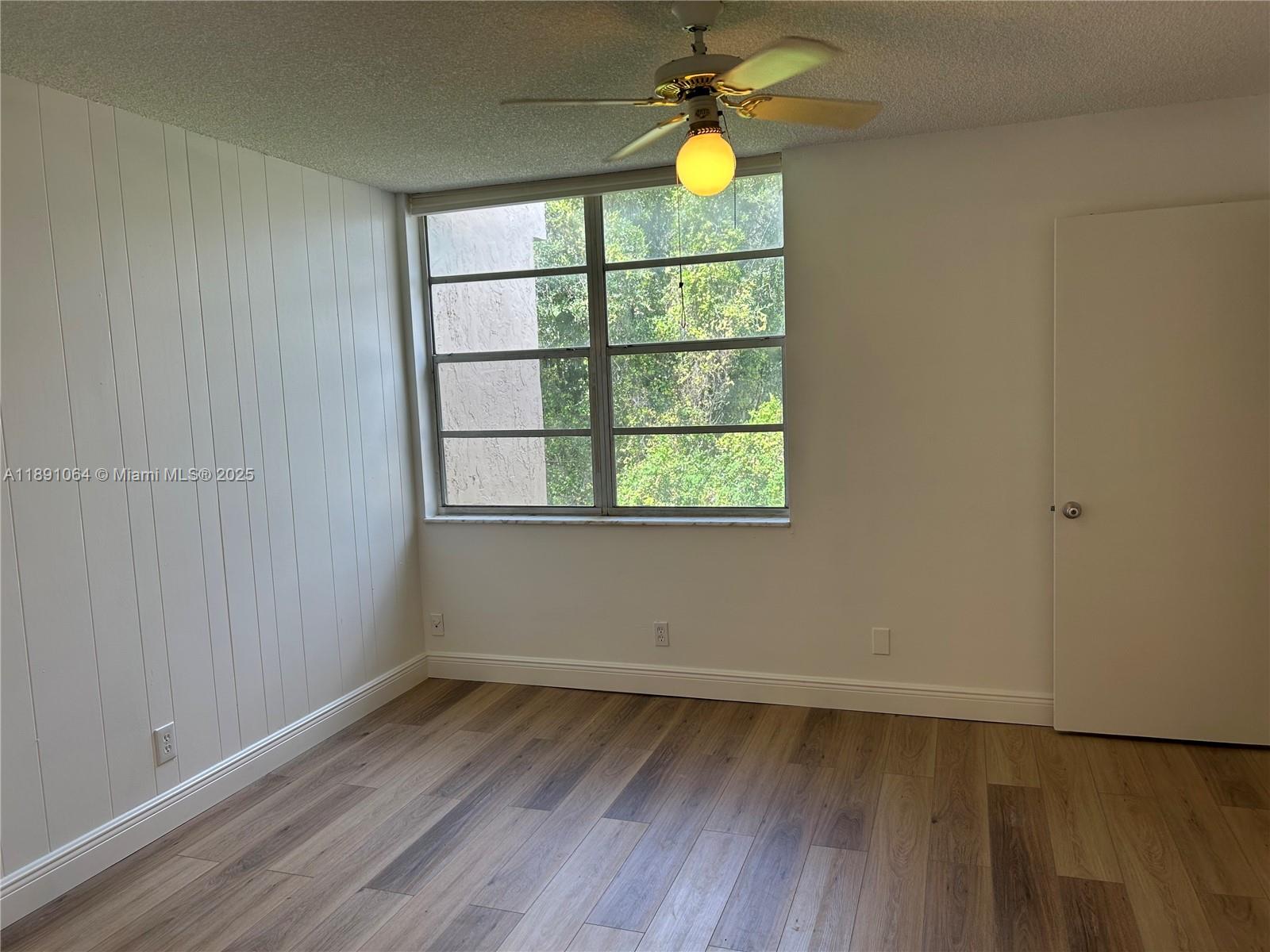 9430 Live Oak Place, Unit 404 Davie, FL 33324 - Photo 17 of 28 a view of an empty room with wooden floor and a window