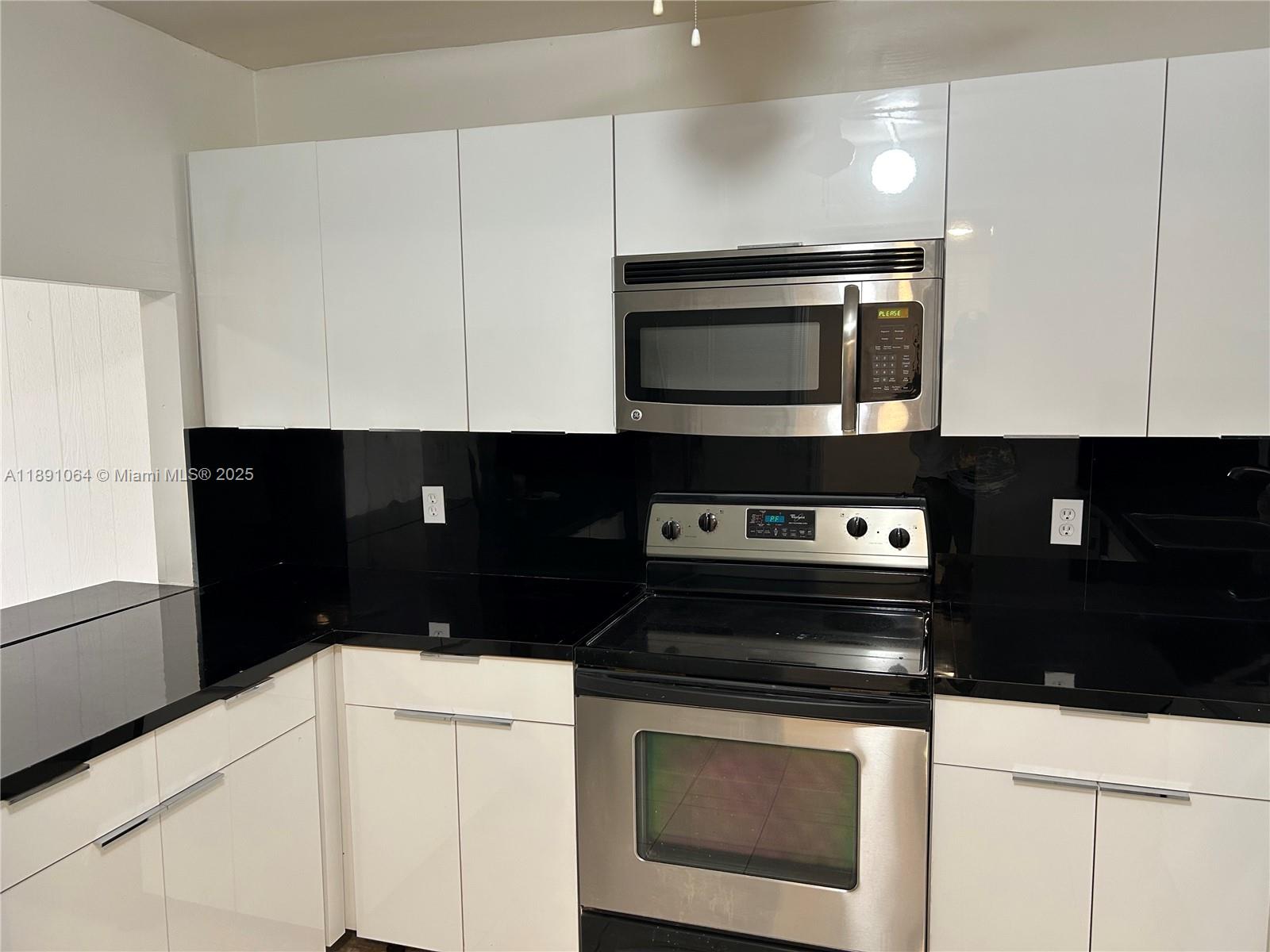 9430 Live Oak Place, Unit 404 Davie, FL 33324 - Photo 2 of 28 a kitchen with a stove and a microwave