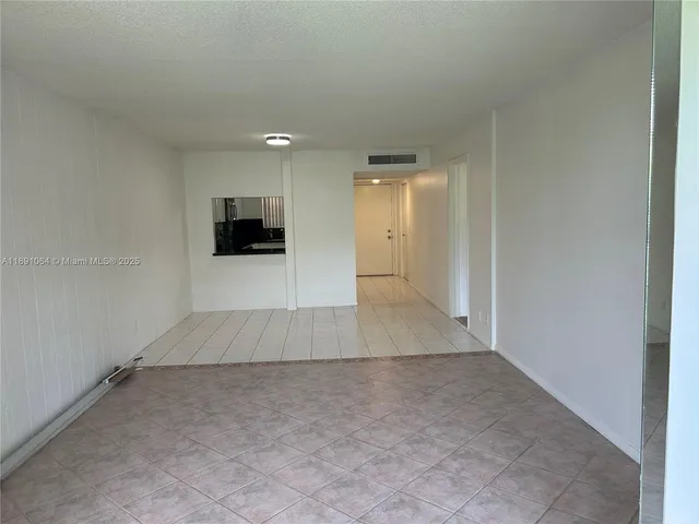 an empty room with kitchen space and a window
