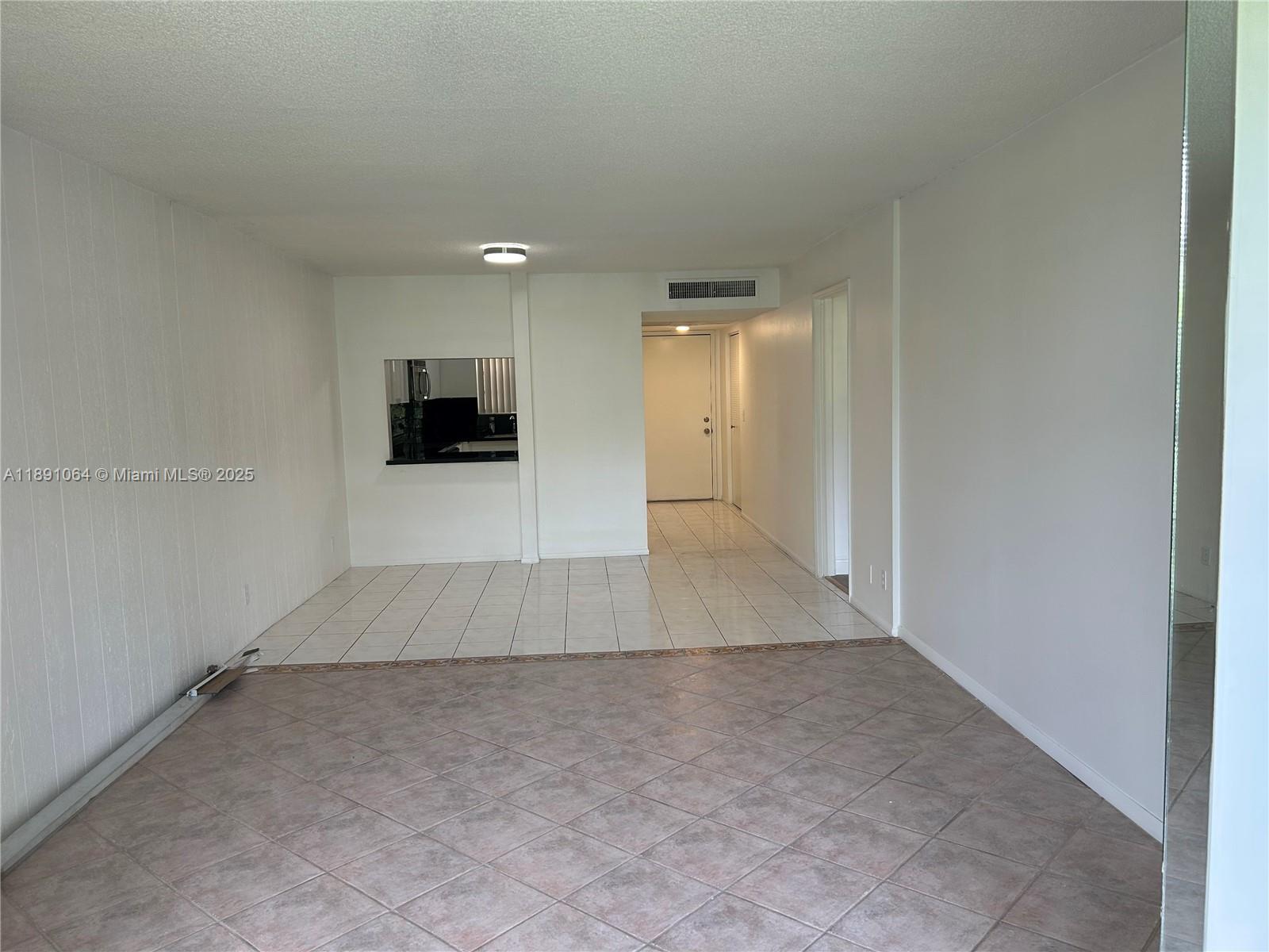 9430 Live Oak Place, Unit 404 Davie, FL 33324 - Photo 7 of 28 an empty room with kitchen space and a window