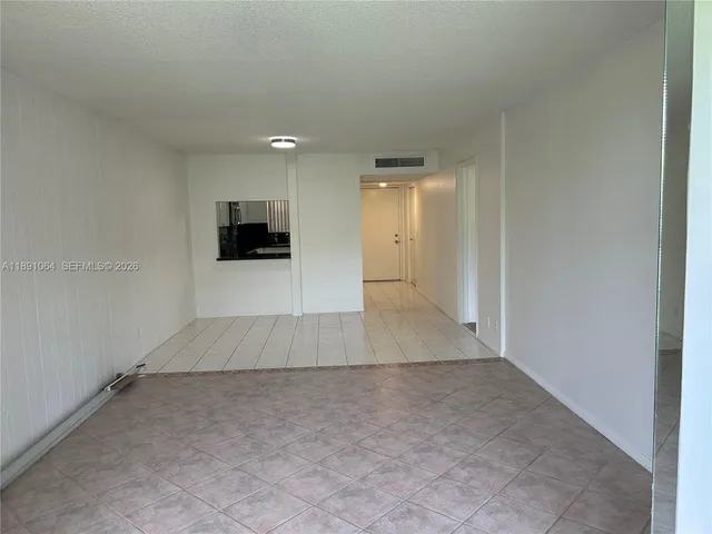 an empty room with kitchen space and a window