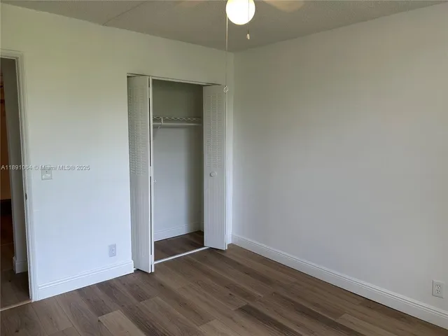 an empty room with wooden floor and closet