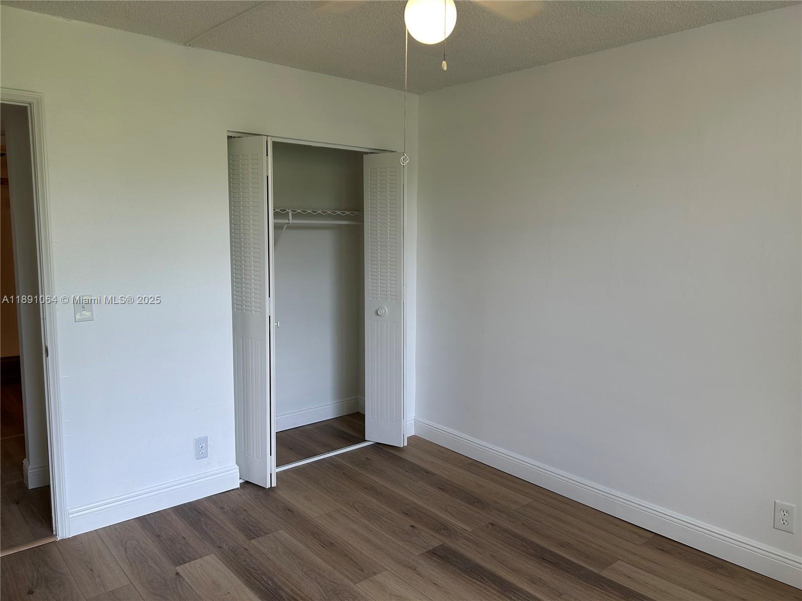 9430 Live Oak Place, Unit 404 Davie, FL 33324 - Photo 10 of 28 an empty room with wooden floor and closet