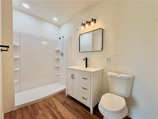 a bathroom with a toilet a sink a mirror and bathtub