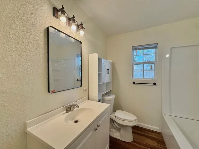 a bathroom with a toilet a sink and mirror