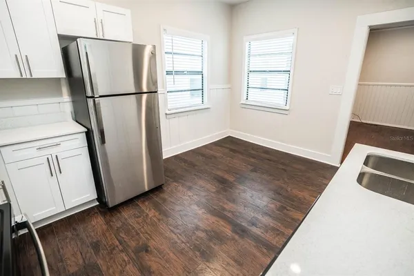 a view of kitchen with wooden floor and electronic appliances