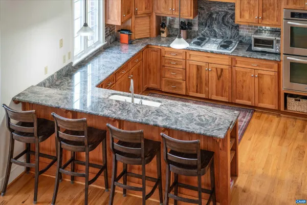a bathroom with a granite countertop shower a mirror and a sink