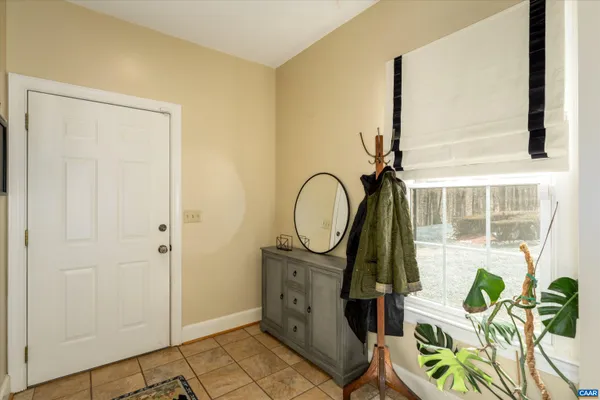 a bedroom with a bed painting on wall and a large window