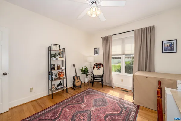 a spacious bedroom with a bed and wooden floor
