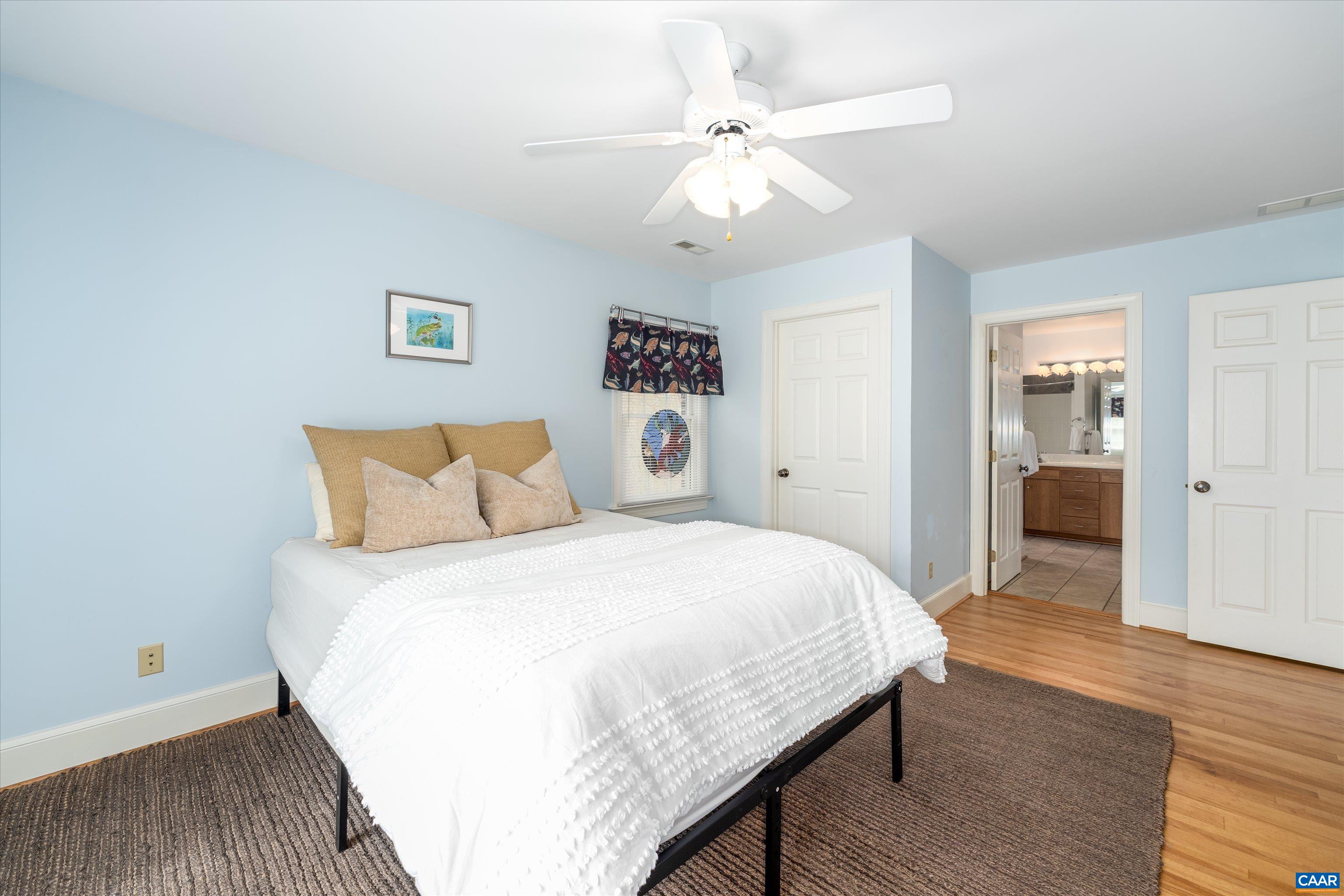 4444 Woods Edge Road Troy, VA 22974 - Photo 50 of 74 a bedroom with a large bed and a chandelier