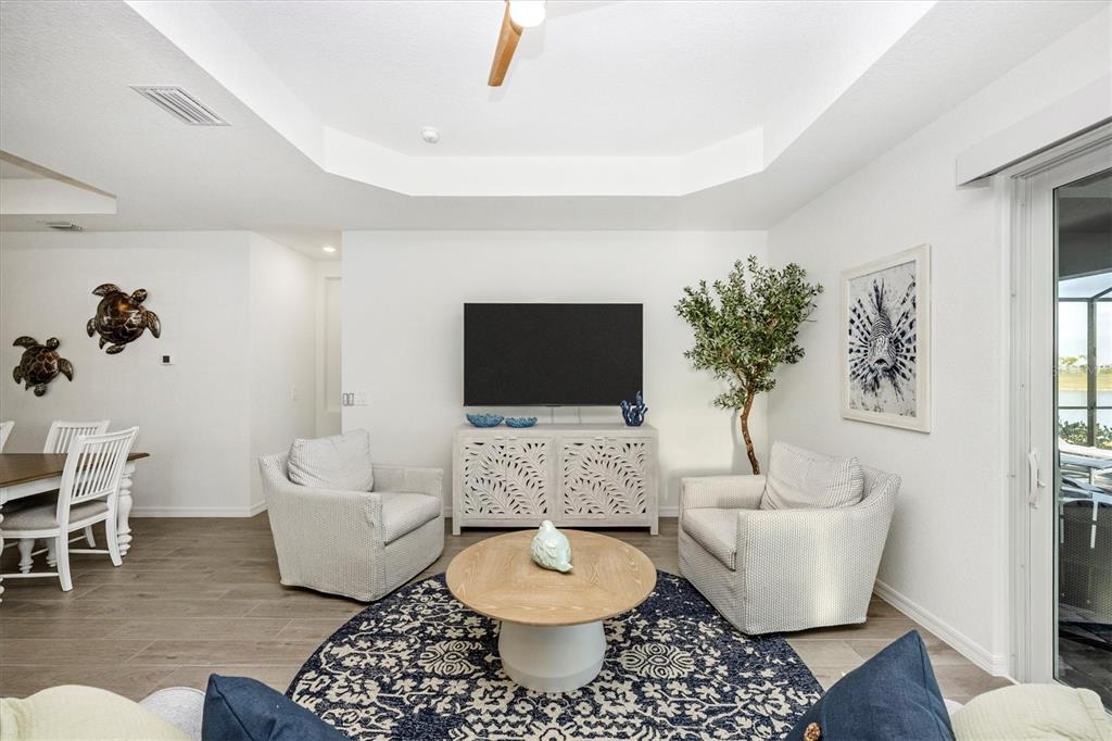 12950 Tulum Loop Venice, FL 34293 - Photo 24 of 98 a living room with furniture a rug and a potted plant