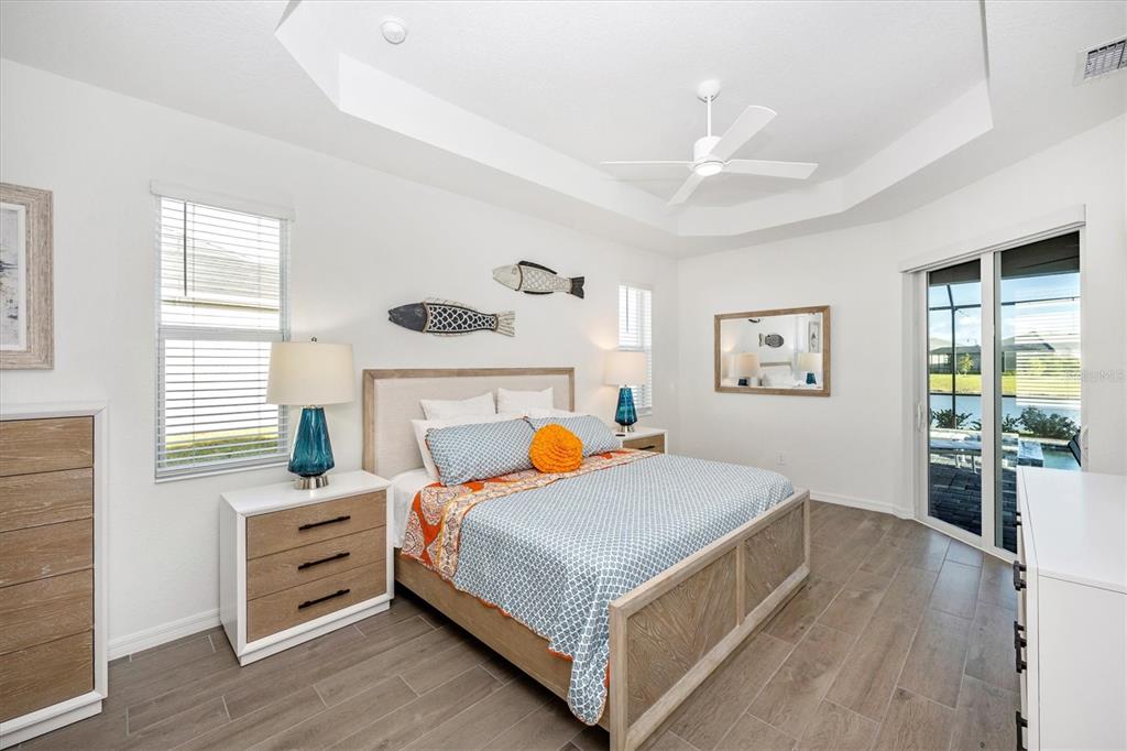 12950 Tulum Loop Venice, FL 34293 - Photo 27 of 98 a bedroom with a bed and wooden floor