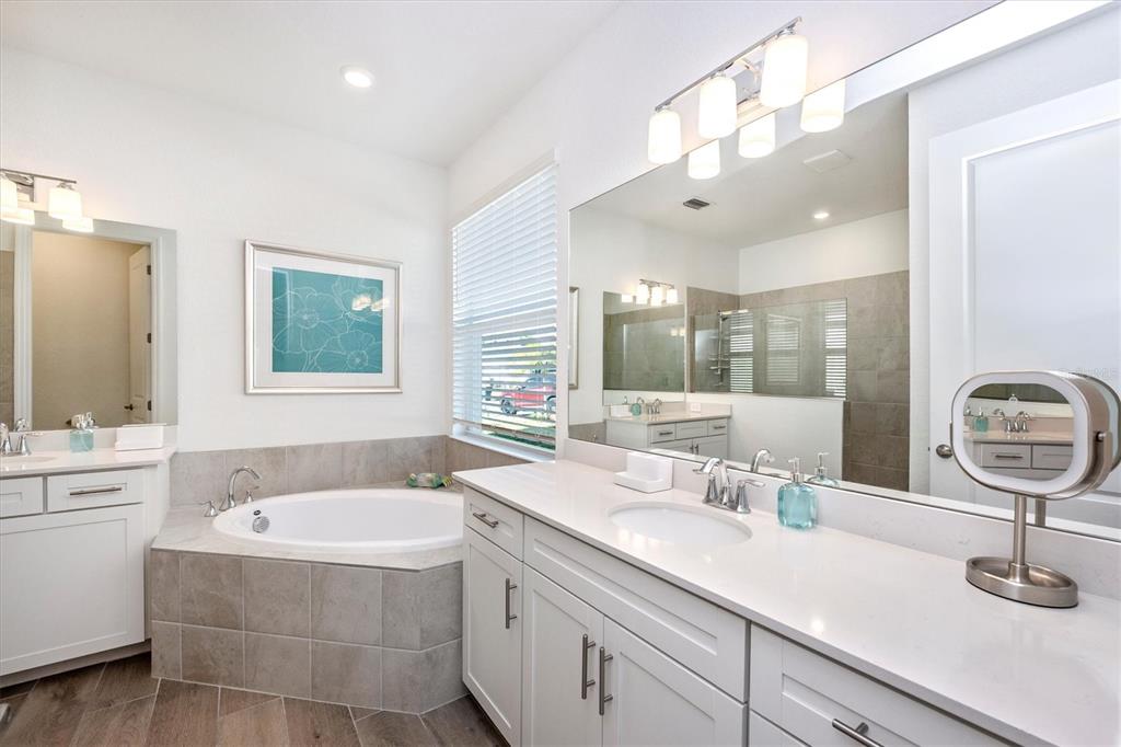 12950 Tulum Loop Venice, FL 34293 - Photo 30 of 98 a bathroom with a tub sink and mirror