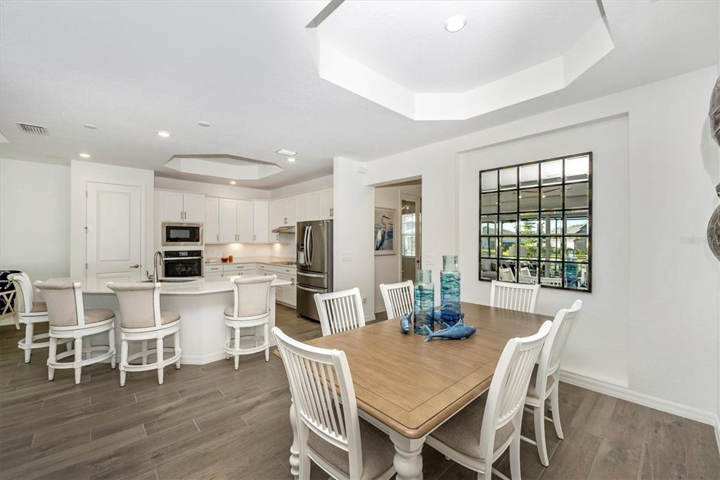 12950 Tulum Loop Venice, FL 34293 - Photo 10 of 98 a dining room with furniture window and wooden floor