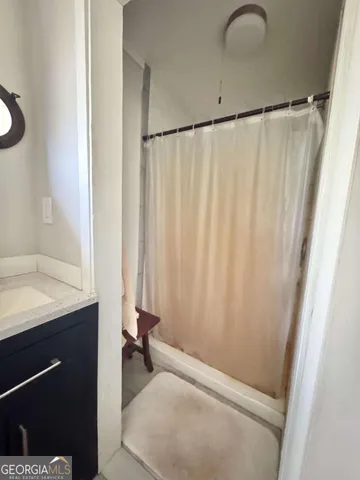 a bathroom with a shower and a sink