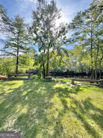 a view of yard with swimming pool and green space